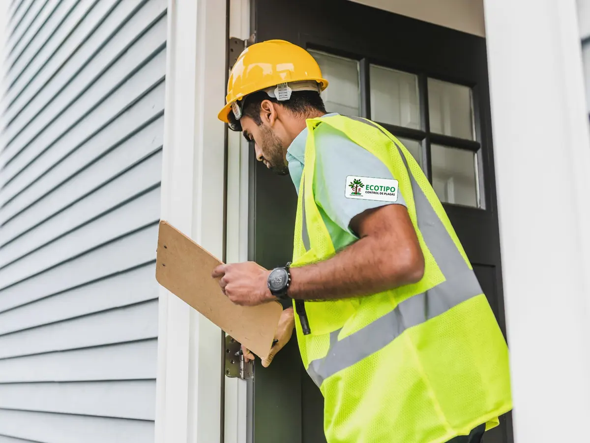 Técnico revisando el exterior de una vivienda durante una inspección de control de plagas